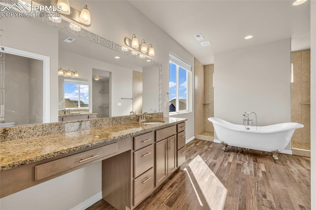 Image 22 of 44: Full bath featuring vanity, a freestanding bath, dark wood-type flooring, a