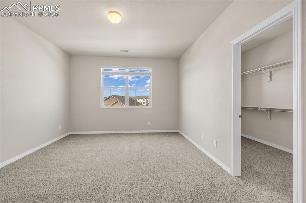 Image 27 of 44: Unfurnished bedroom with light carpet and a spacious closet