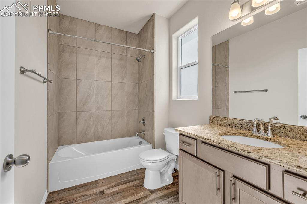 Image 29 of 44: Bathroom featuring tub / shower combination, vanity, and light wood-style f
