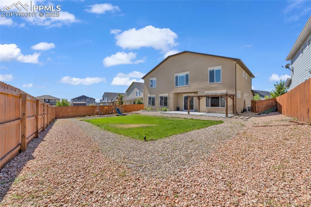 Image 40 of 44: Rear view of house with a patio, a fenced backyard, and stucco siding