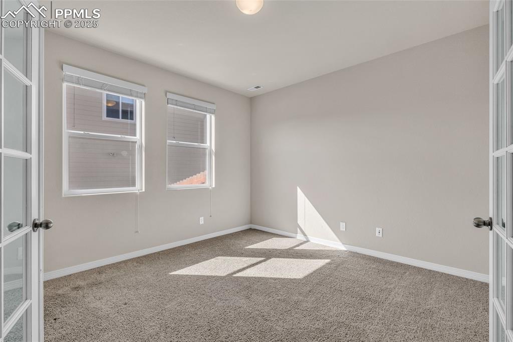 Image 7 of 44: Unfurnished room featuring light colored carpet and french doors