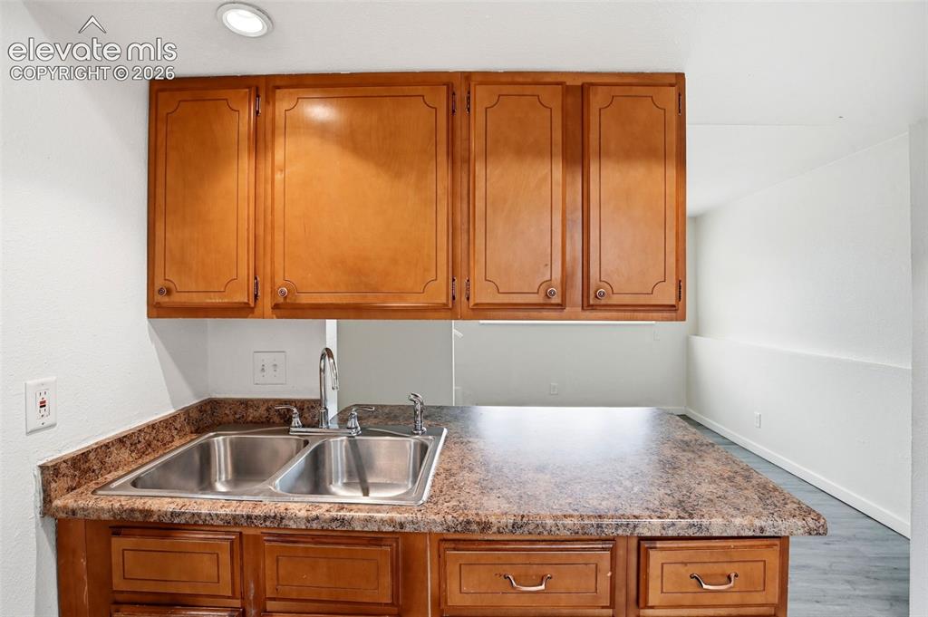 Image 14 of 31: Wood-finish cabinetry with decorative panels, double basin stainless steel 