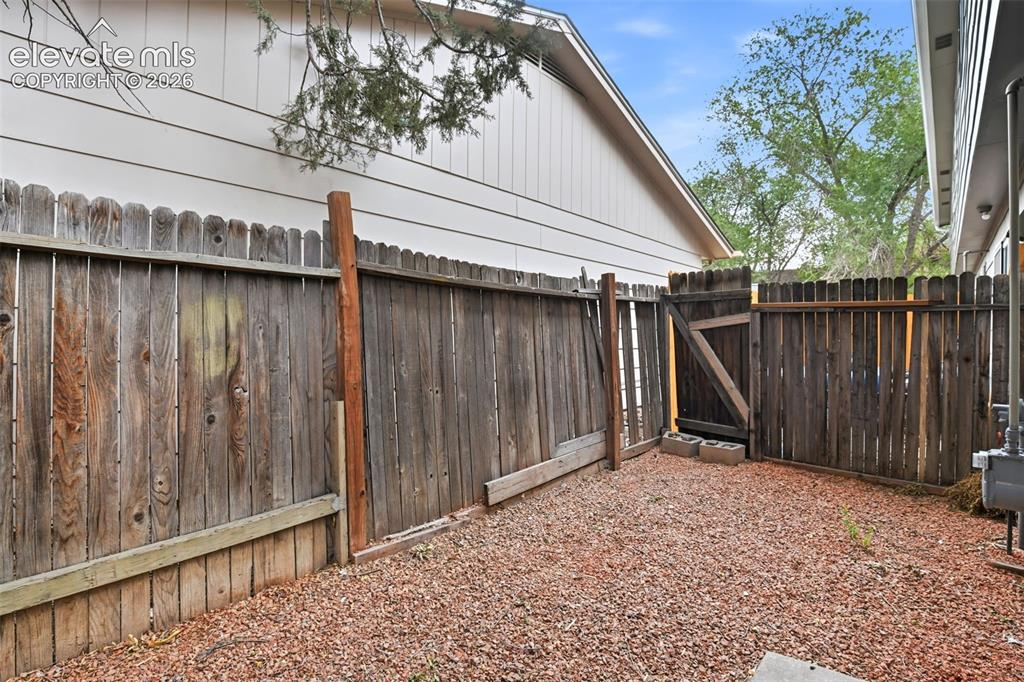 Image 19 of 31: Fenced outdoor space featuring a wood privacy fence with gate and gravel gr