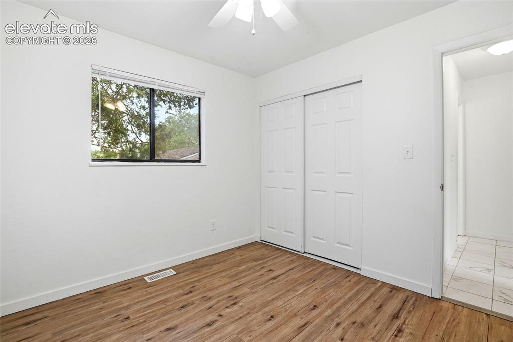 Image 23 of 31: Could also be a Bedroom. Wood-finish flooring, white walls, and a window w