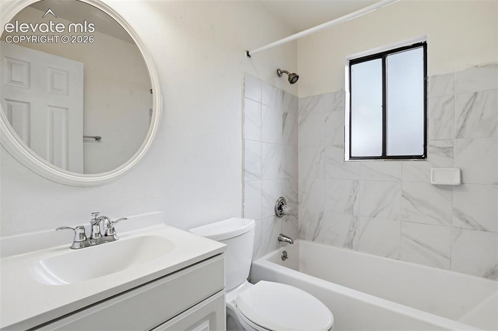 Image 29 of 31: Bathroom featuring a white vanity with integrated sink, chrome faucet, oval