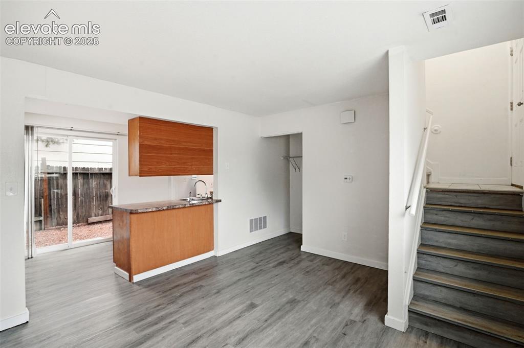 Image 8 of 31: Stairs to the Front Door and Access to the Kitchen from the Living Room