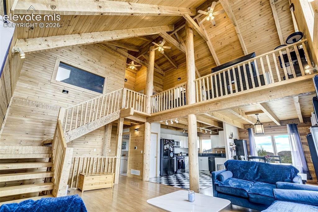 Image 10 of 50: Expansive great room featuring a vaulted wood-finish ceiling with exposed b