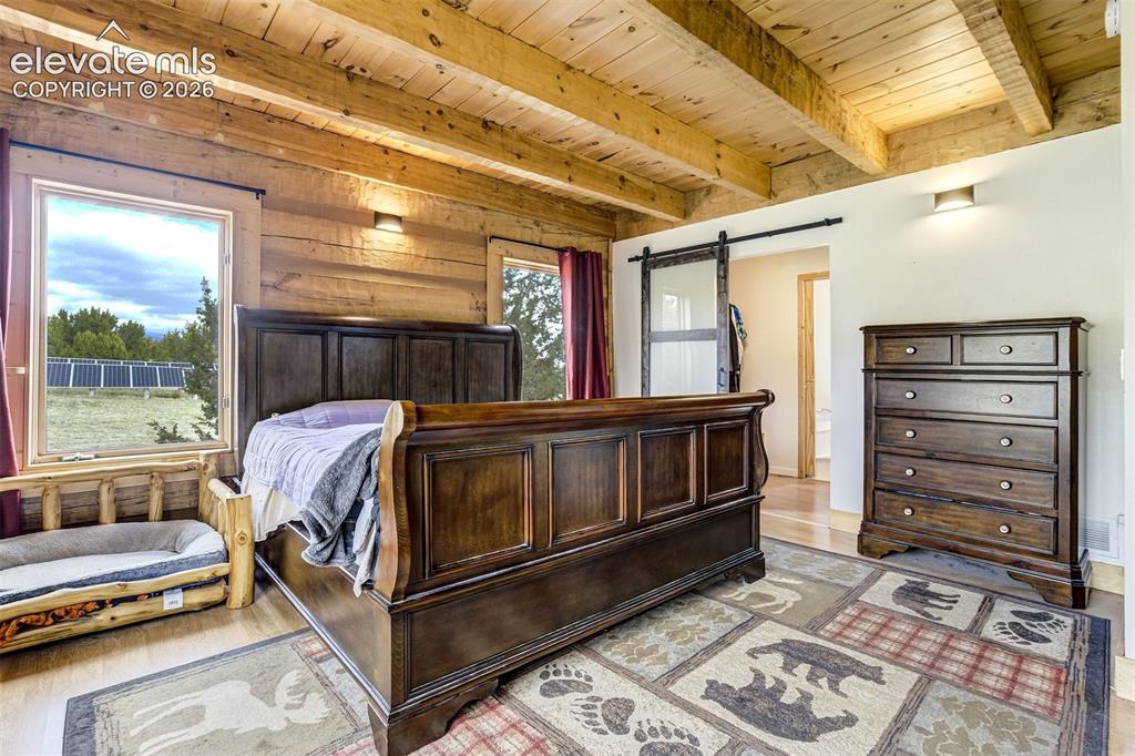 Image 19 of 50: Exposed timber beam ceiling over wood-finish flooring