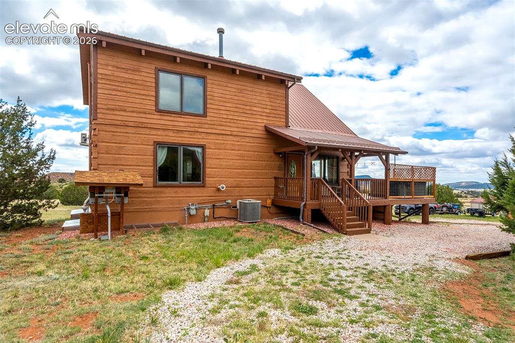 Image 2 of 50: Two-story exterior featuring wood-plank siding, a metal roof, and a covered