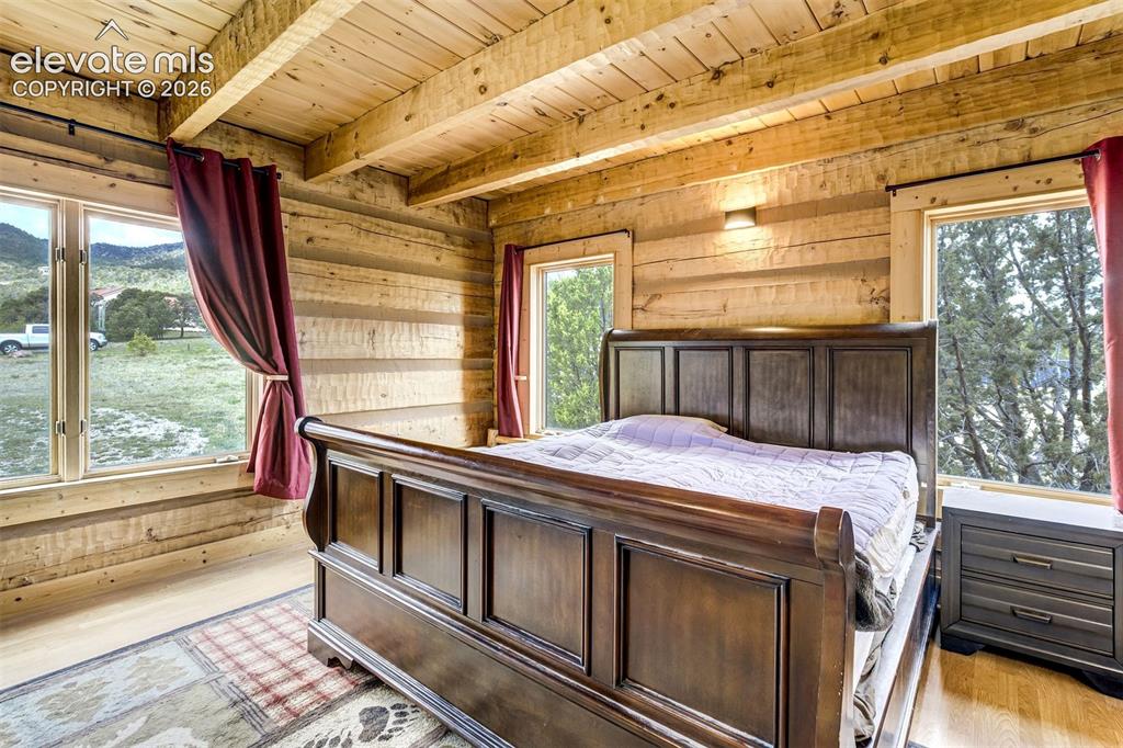 Image 20 of 50: Log cabin interior featuring exposed wood beam ceiling, natural wood walls,