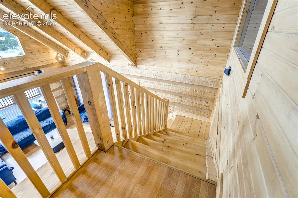Image 31 of 50: Wood-finish stairs with a coordinating wood railing, wood-paneled walls, an
