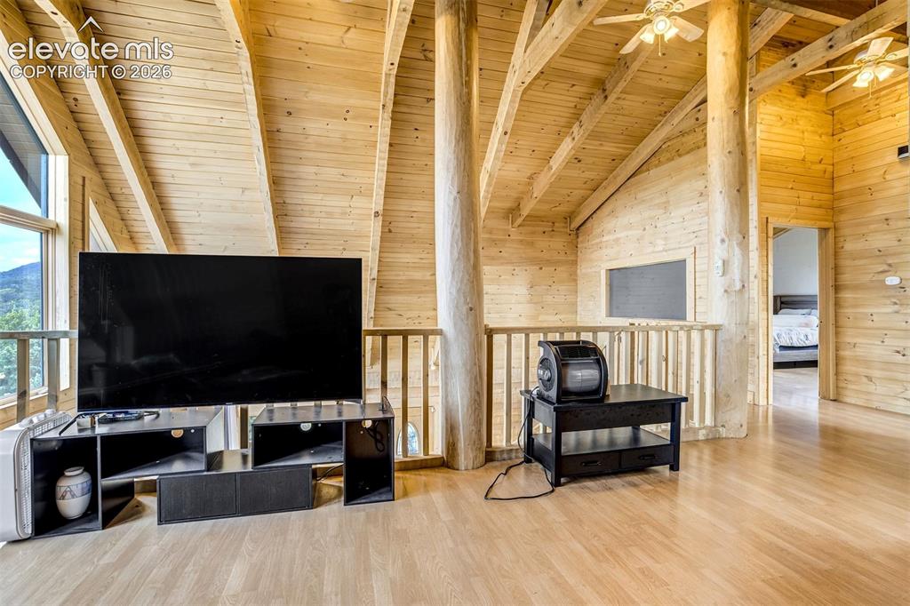 Image 35 of 50: Vaulted ceiling with exposed wood beams, natural wood plank walls, light wo