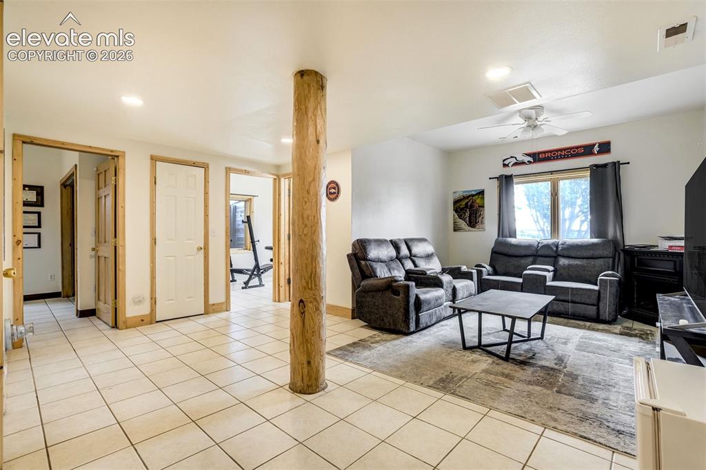 Image 37 of 50: Spacious room featuring light-colored tile flooring, multiple doorways with