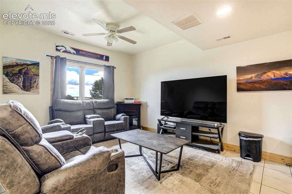 Image 39 of 50: Interior room featuring a large window with white trim, a ceiling fan with