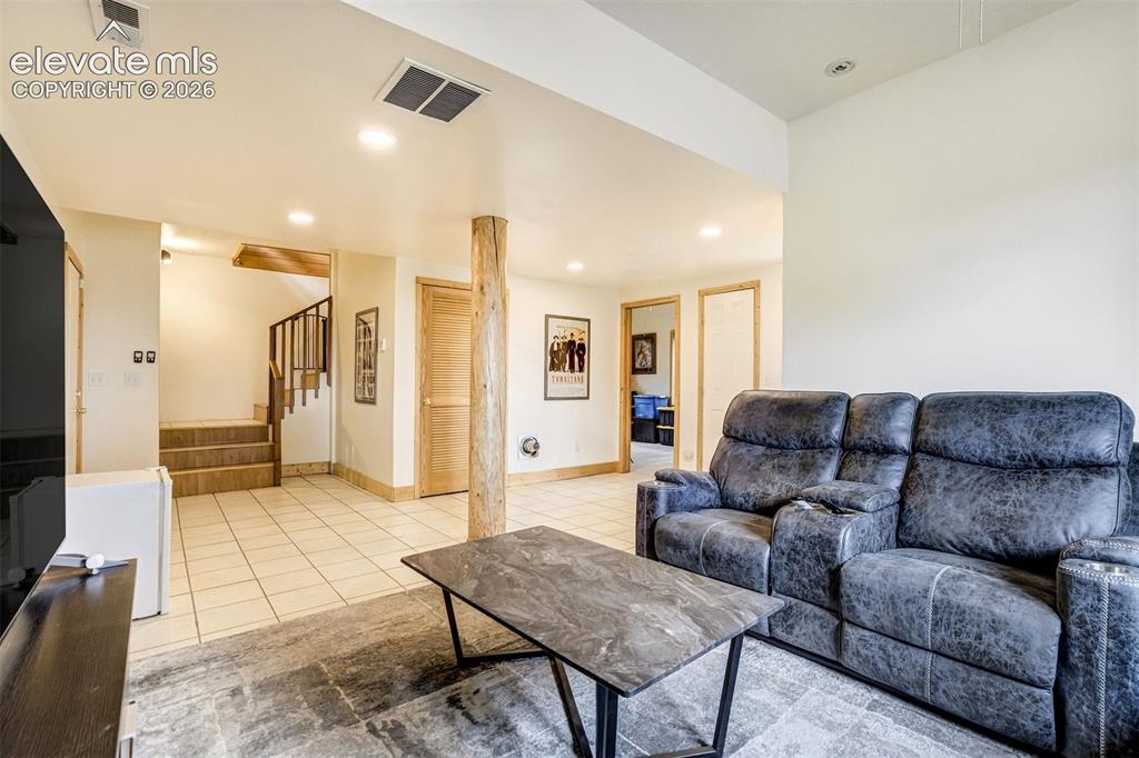 Image 40 of 50: Spacious room featuring light-toned tile flooring, recessed lighting, a nat