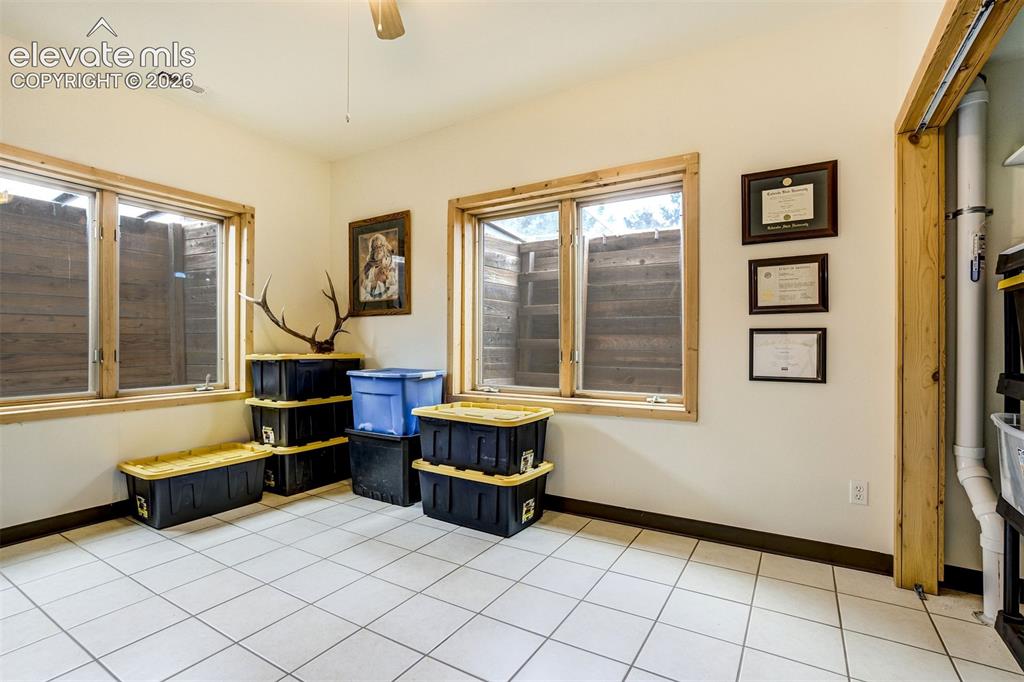 Image 42 of 50: Room featuring white tile flooring, two windows with natural wood trim, whi