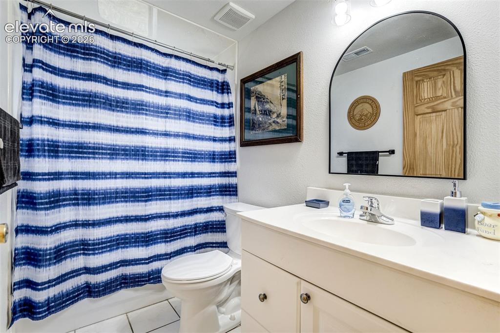 Image 43 of 50: Full bathroom featuring a white vanity with integrated sink, chrome faucet,