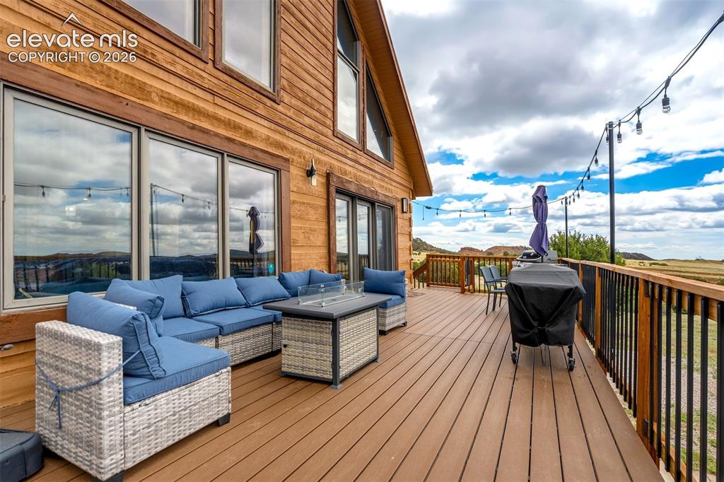 Image 44 of 50: Spacious outdoor deck featuring wood-finish flooring, black metal railings,