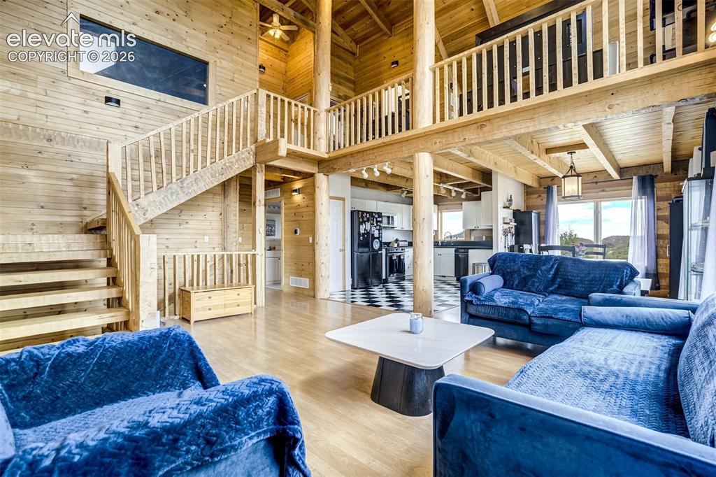 Image 9 of 50: Expansive open-concept living space featuring wood-finish flooring, exposed