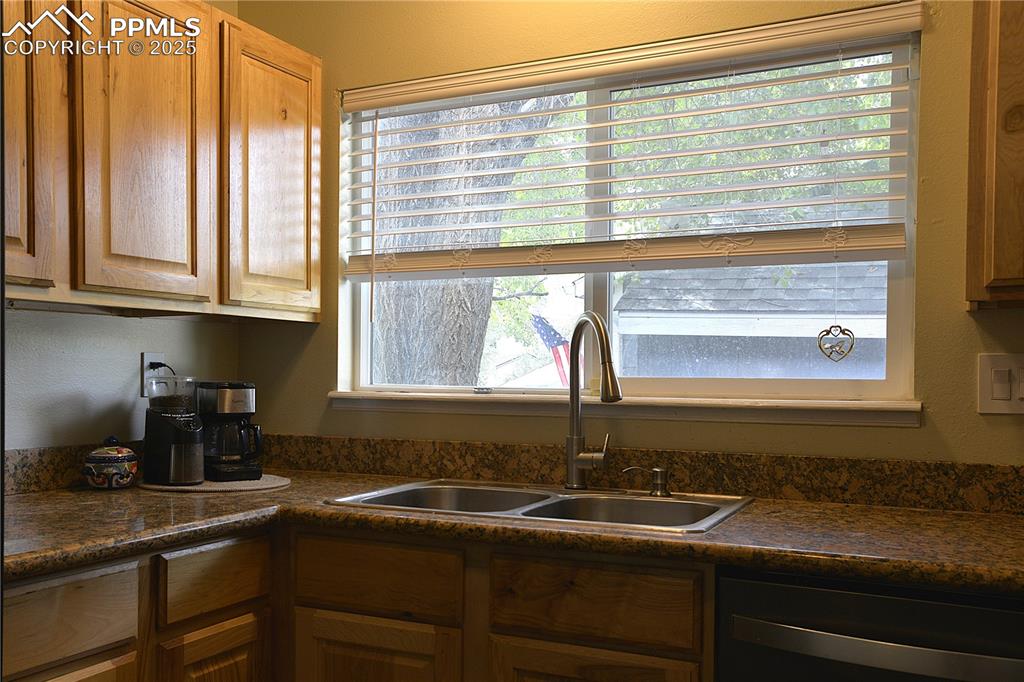 Image 11 of 29: Kitchen featuring dark countertops and dishwashing machine