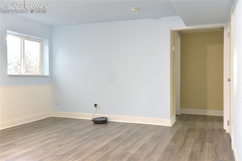 Image 20 of 29: Basement Family Room featuring wainscoting and solid surface flooring