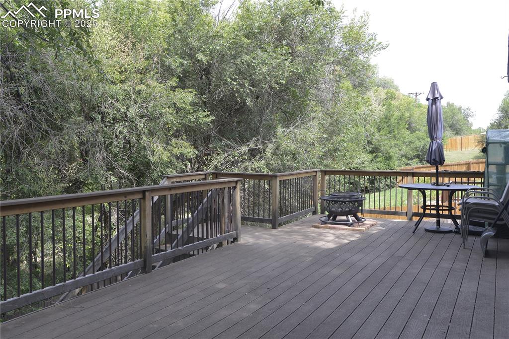 Image 27 of 29: Wooden deck featuring outdoor dining space, Private Tree Lined Rear Yard