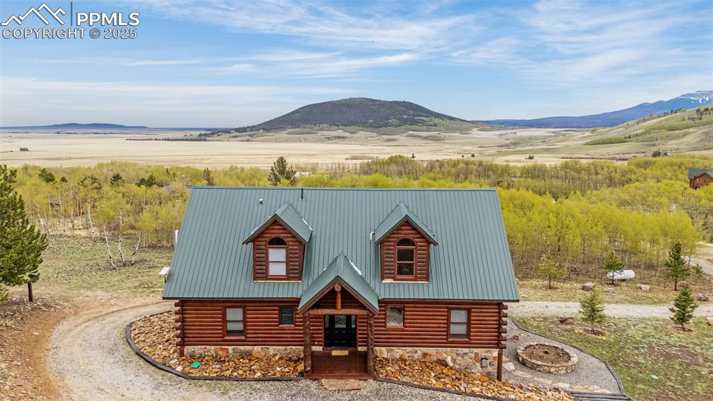 Caption: View of front of home with a mountain view, log siding, and metal roof