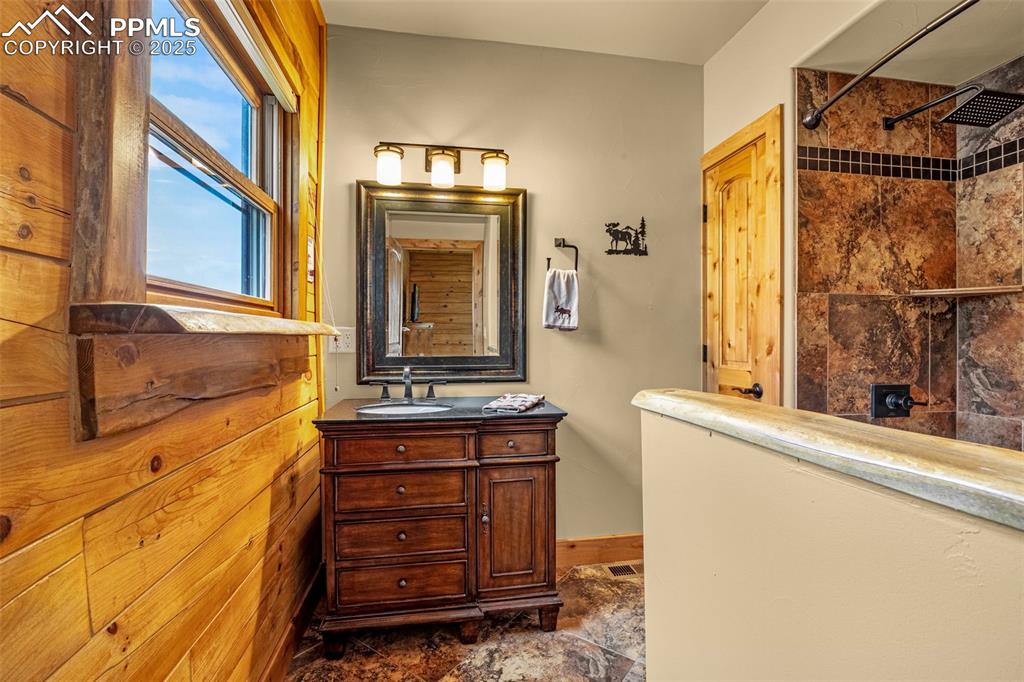 Image 18 of 45: Bathroom featuring a tile shower and vanity