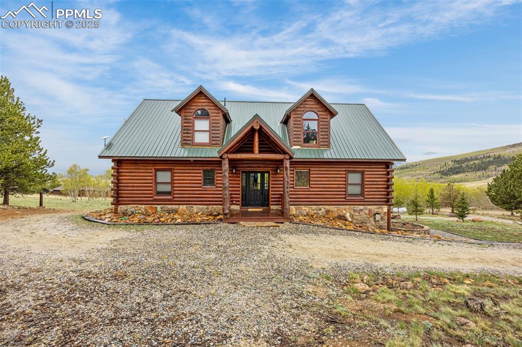Image 2 of 45: Log cabin with log exterior and driveway