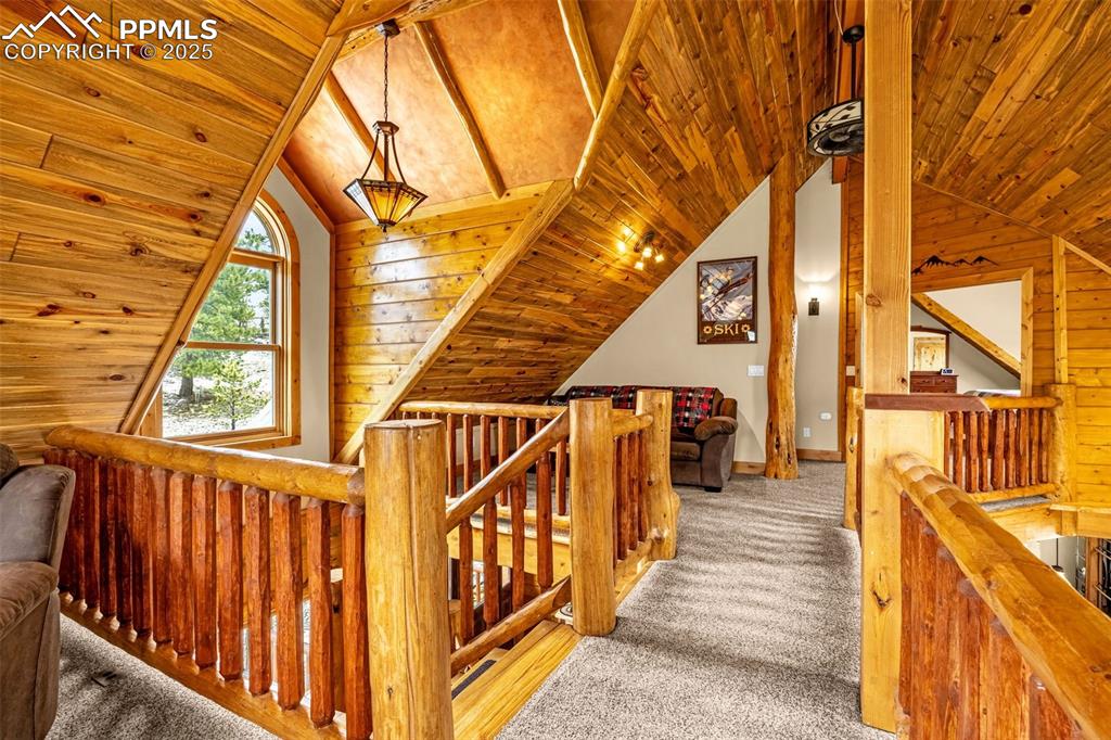 Image 22 of 45: Corridor with an upstairs landing, wood ceiling, lofted ceiling, carpet, an
