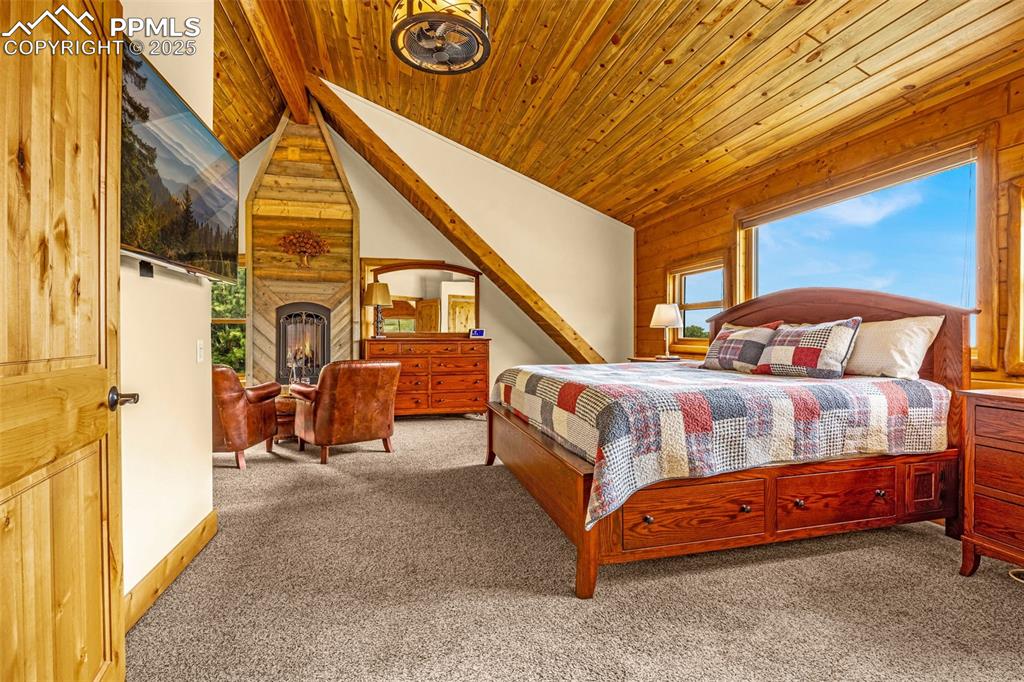 Image 23 of 45: Bedroom with carpet flooring and wooden ceiling