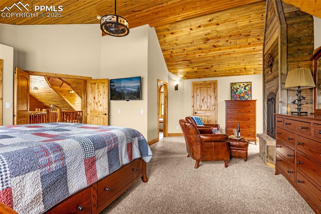 Image 24 of 45: Bedroom featuring wood ceiling, carpet, high vaulted ceiling, and baseboard