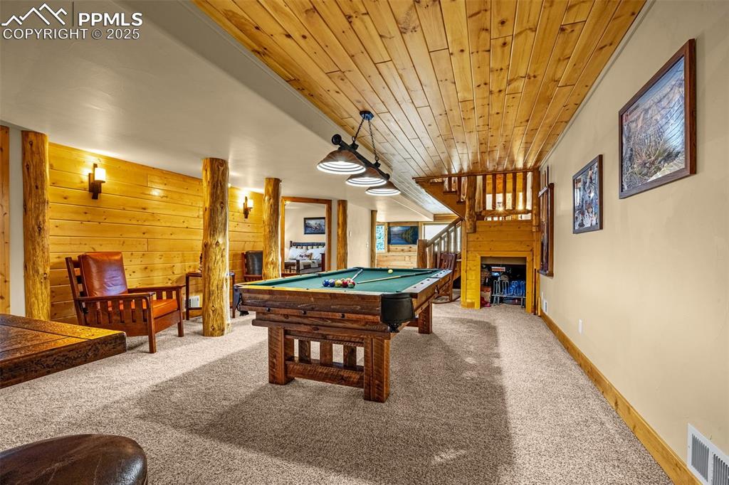 Image 30 of 45: Game room with carpet floors, wood ceiling, pool table, wooden walls, and b
