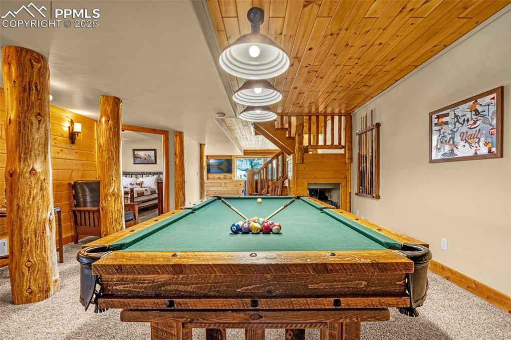 Image 31 of 45: Game room featuring carpet flooring, pool table, baseboards, and wooden wal