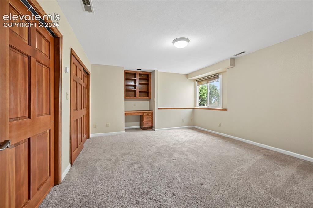 Image 38 of 45: Basement bedroom could be craft room with built ins!
