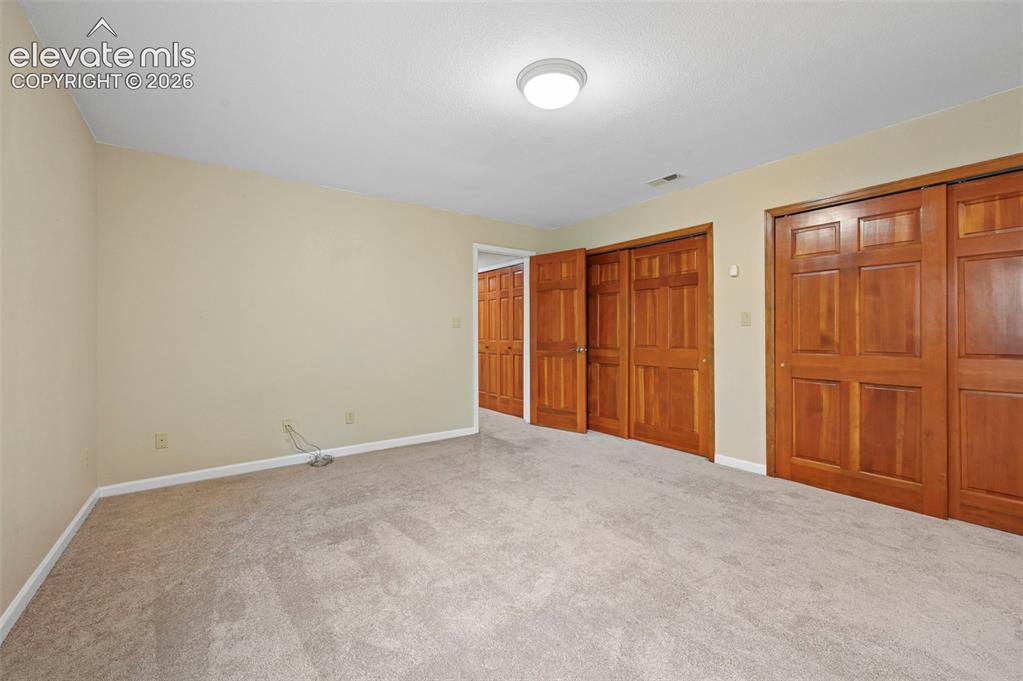 Image 39 of 45: Basement bedroom could be craft room with built in desk and abundant closet