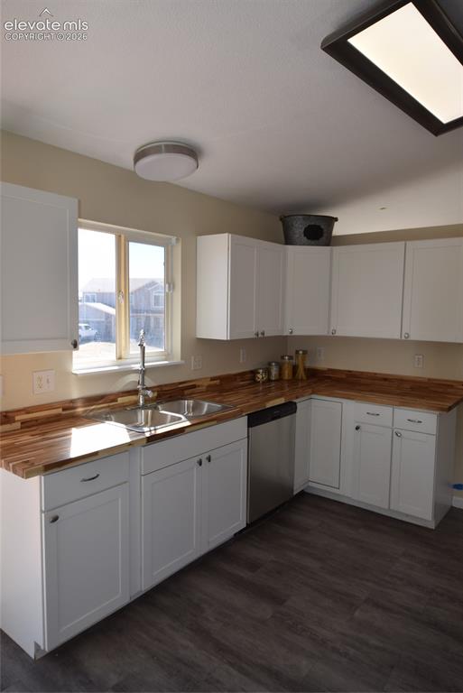 Image 11 of 44: Kitchen featuring white shaker-style cabinetry, wood-finish countertops, st