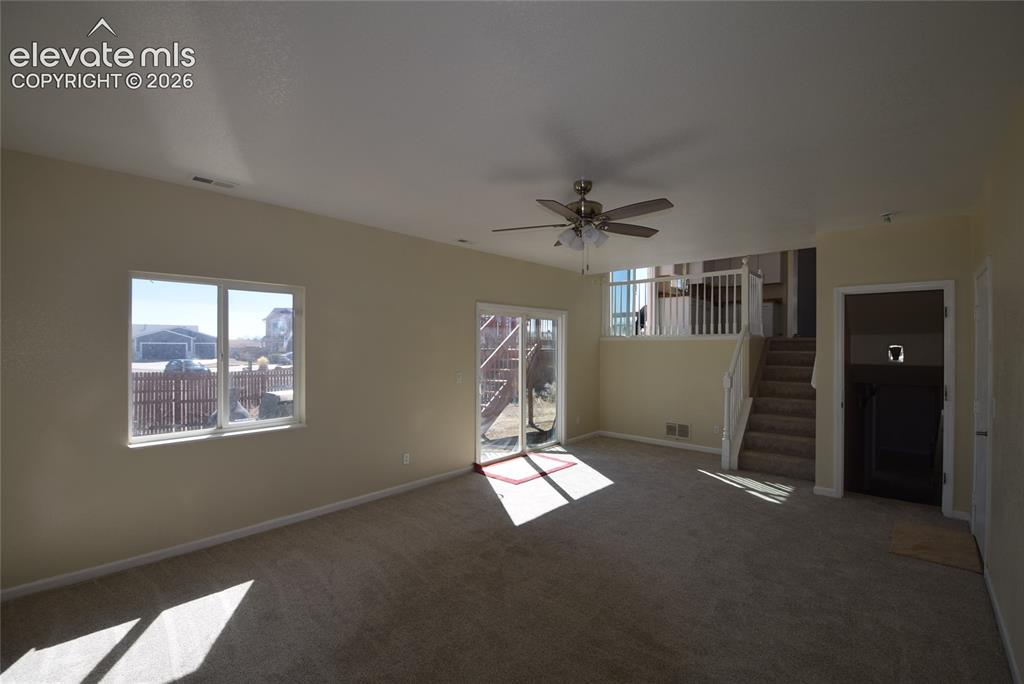 Image 16 of 44: Expansive carpeted area featuring a ceiling fan with light fixture, a large