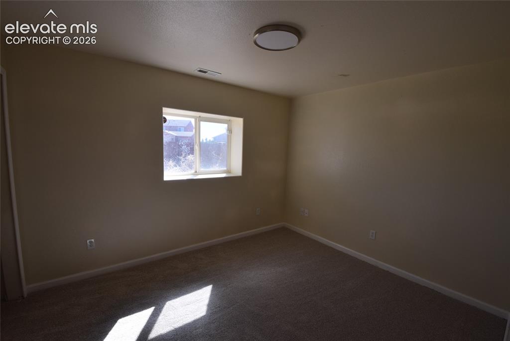 Image 22 of 44: Neutral-toned interior room featuring a double-paned window, carpeted floor