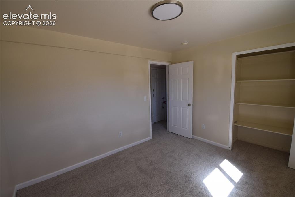 Image 23 of 44: Neutral-toned room featuring wall-to-wall carpeting and a flush-mount ceili