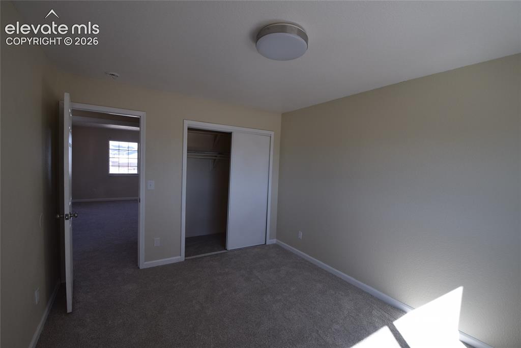 Image 30 of 44: Carpeted room with neutral painted walls and a flush-mount ceiling light fi