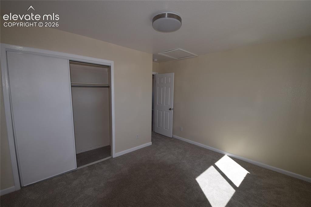 Image 31 of 44: Neutral-toned walls complement the gray carpeting