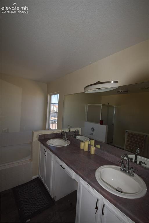 Image 36 of 44: Dual vanity with white cabinetry and integrated sinks, a large wall-mounted