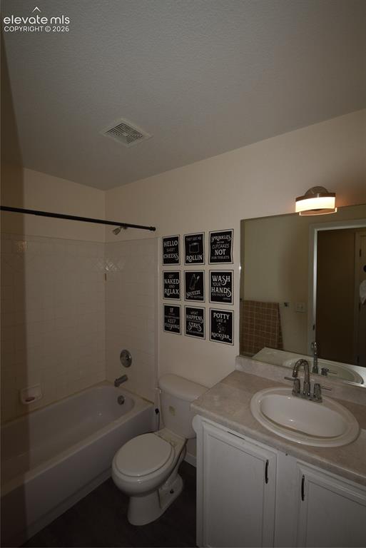 Image 37 of 44: Full bathroom featuring a white porcelain tub with shower, white toilet, an