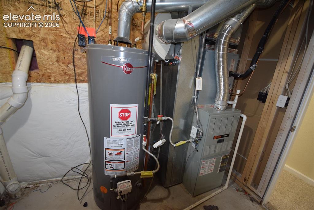 Image 39 of 44: Utility area featuring a water heater and furnace with exposed ductwork, PE