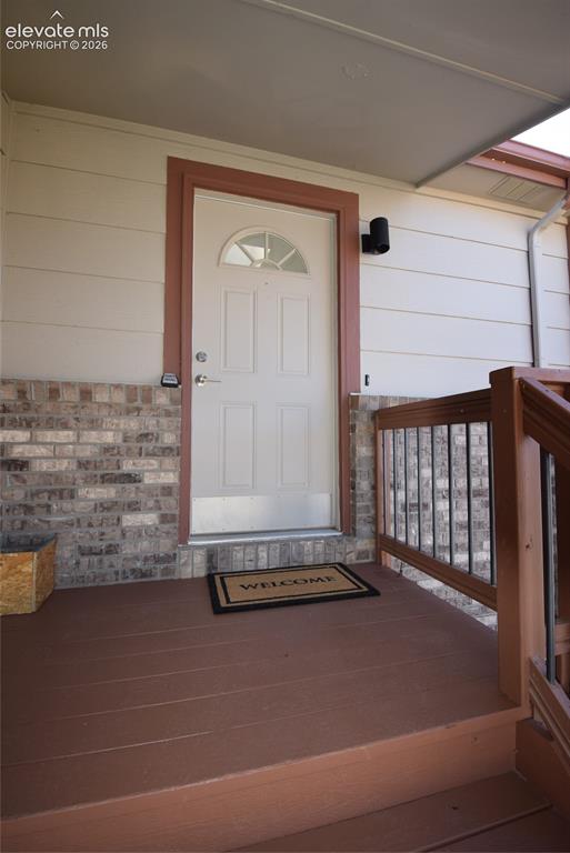 Image 4 of 44: Entryway featuring a white door with an arched glass insert, flanked by a c