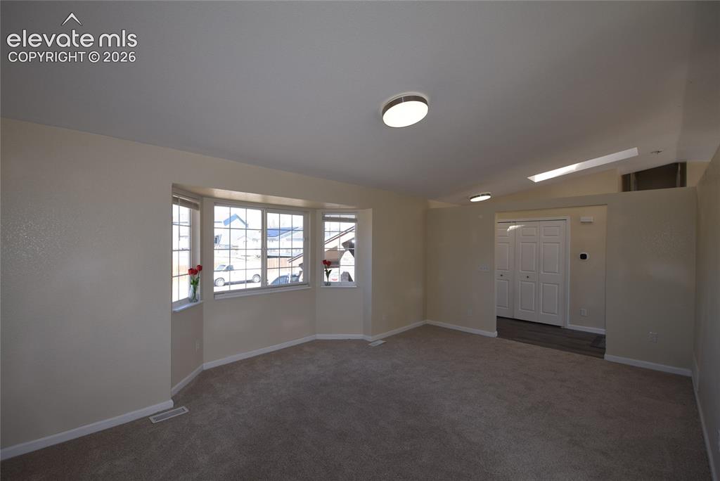 Image 6 of 44: Living area featuring a bay window with multiple panes, neutral-toned walls