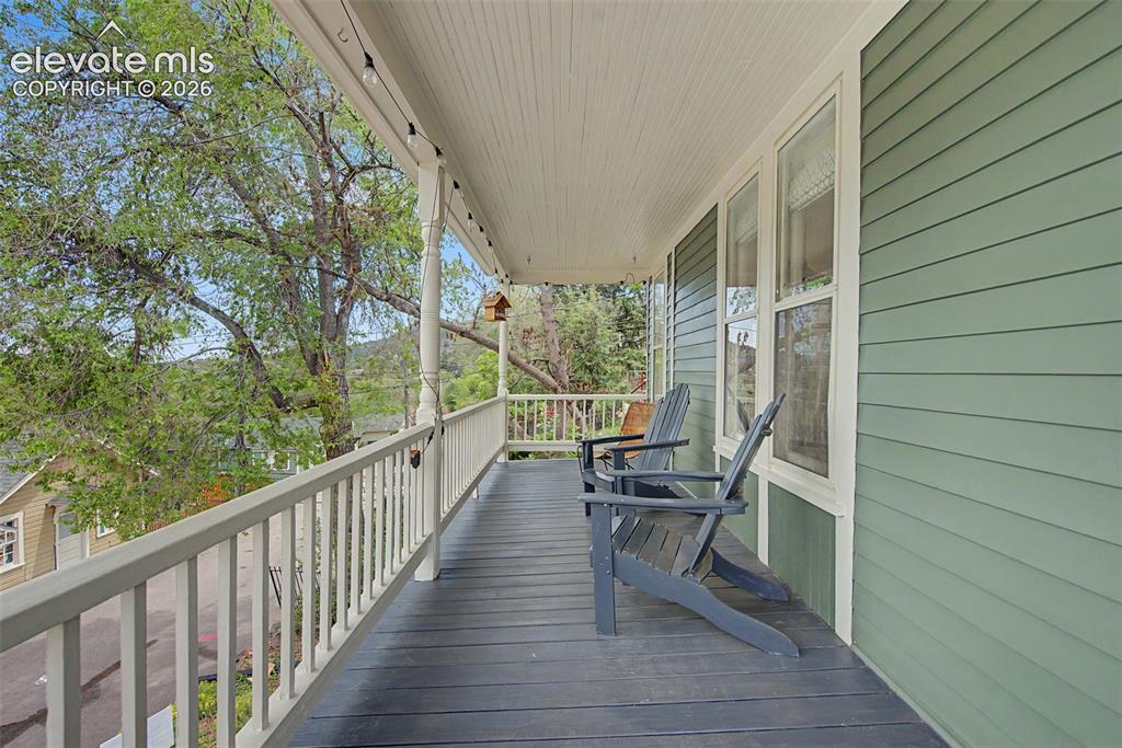 Image 10 of 50: Covered porch overlooking road with red rock and mountain views