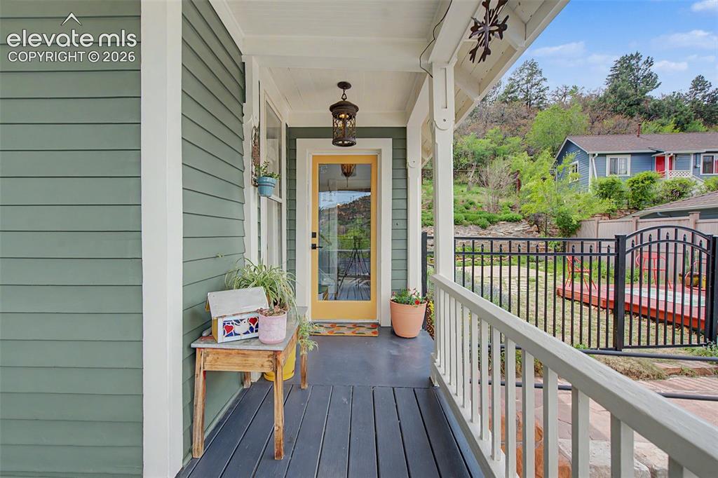 Image 11 of 50: Covered front porch entrance to main home featuring a full-light entry door