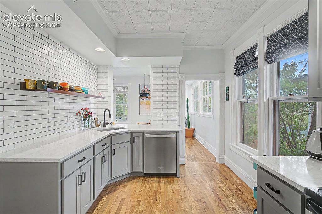 Image 22 of 50: Updated kitchen with light gray cabinetry, Victorian-style ceiling tile, wh